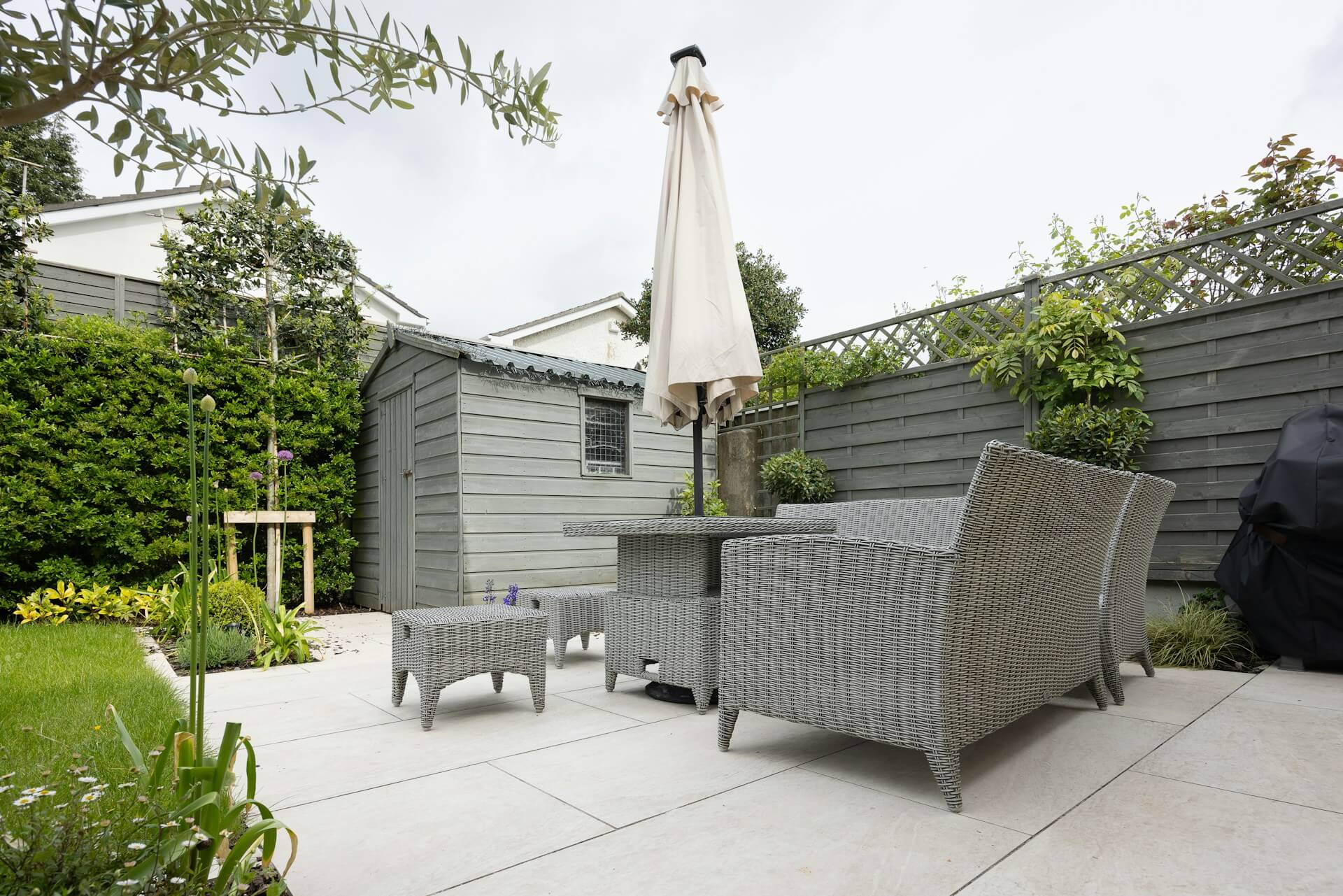 Gartenschirm mit Gartenmöbeln auf der Terrasse